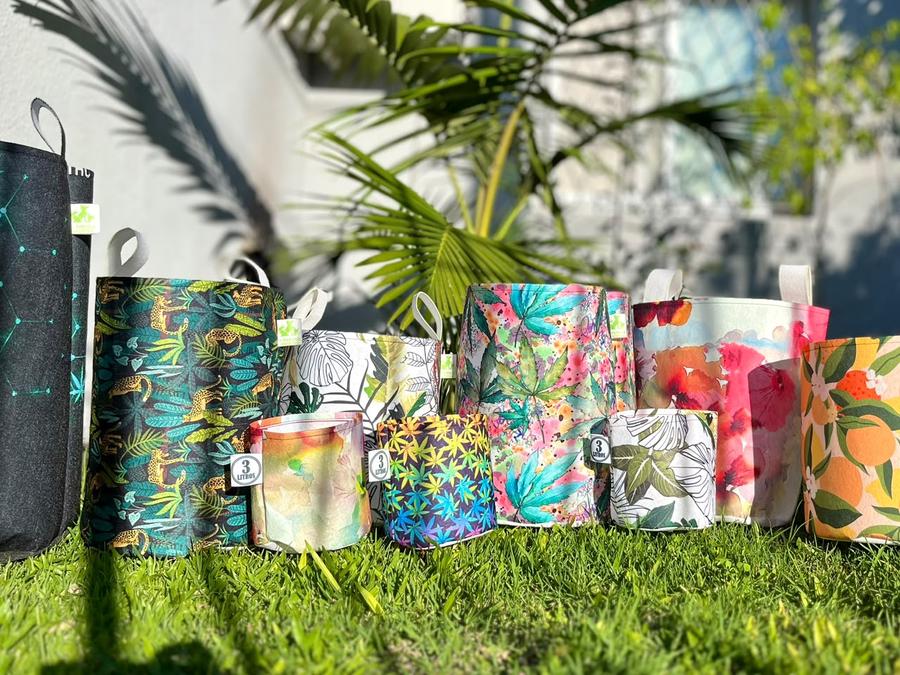Macetas sublimadas de distintas estampas y tamaños sobre el césped